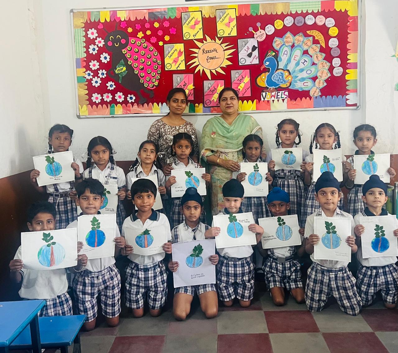 Students showcasing Earth Day art projects in classroom