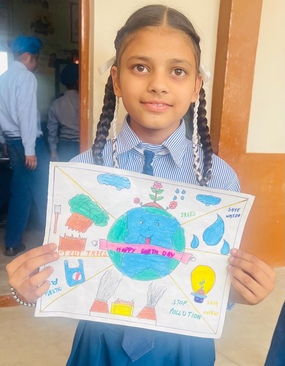 Student with Earth Day drawing